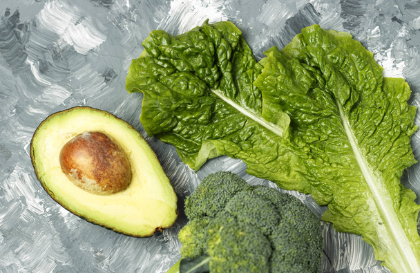 Avokádó, brokkoli, zöld saláta, szürke háttér, diéta fogalma - Fotó, kép