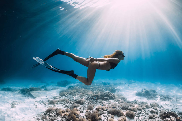 Mulher bonita freediver com barbatanas nadar sobre o mar arenoso e raios de sol subaquático
 - Foto, Imagem