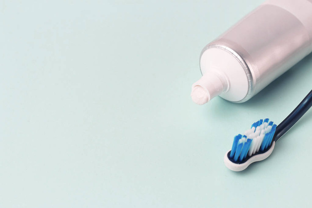 Tüp ve mavi arka plan üzerinde diş fırçası Diş macunu. Dişlerle ilgili sağlık bilgisi kavramı. - Fotoğraf, Görsel