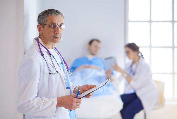 Orvos tartja mappa előtt egy beteg és egy orvos - Fotó, kép