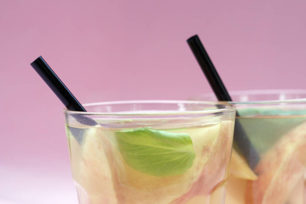 Cocktail aus Pfirsichstücken in einem transparenten Glas, sommerlicher Hintergrund. - Foto, Bild