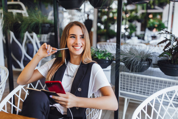 young woman using smartphone at cafe - Fotó, kép