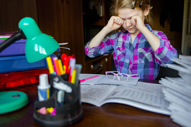 Müde Augen eines Kindes, das Hausaufgaben macht, schreibt und lernt. - Foto, Bild