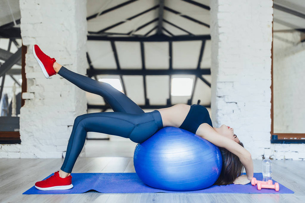 young woman training with fitness ball at gym  - Photo, image