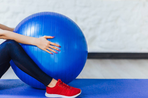 cropped view of young woman training with fitness ball at gym  - Photo, image