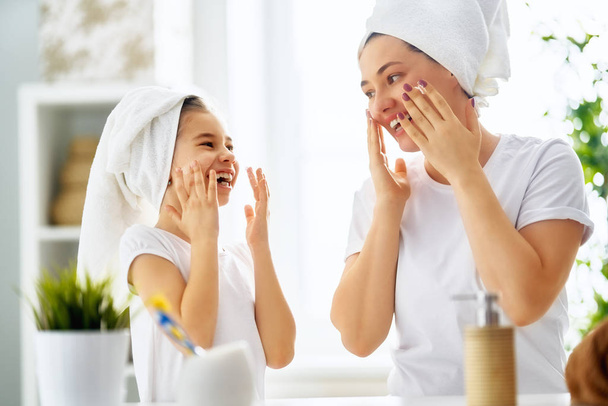 Mother and daughter caring for skin - Foto, Bild