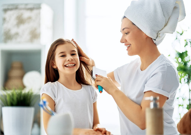 Mother and daughter combing hair - Photo, image