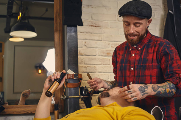 Клиент во время бритья бороды в парикмахерской - Фото, изображение
