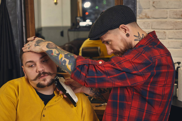 Client during beard shaving in barber shop - 写真・画像