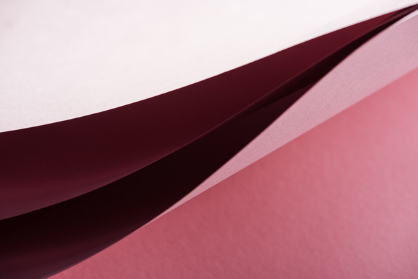 hojas de papel en blanco y colorido sobre fondo rosa con espacio de copia
  - Foto, imagen