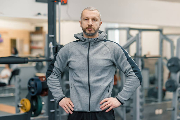 Portrait of handsome sporty man in gym, cross fitness instructor looking at the camera - Foto, immagini