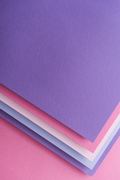 vista superior de hojas vacías de papel azul, blanco, rosa y púrpura sobre fondo rosa
  - Foto, Imagen