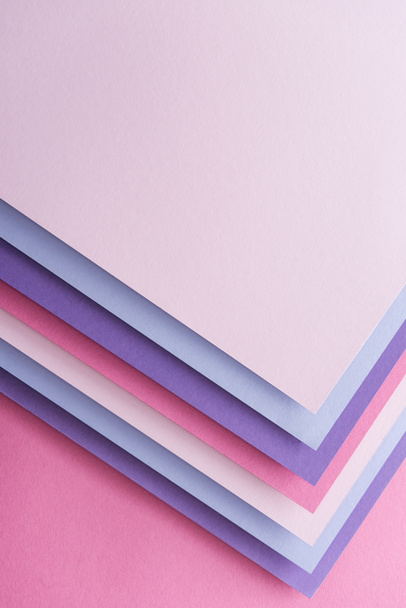 top view of blank blue, white, pink and purple sheets of paper on pink background  - Zdjęcie, obraz