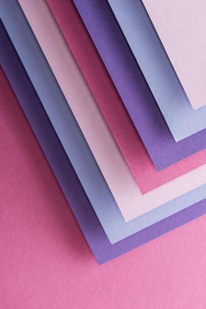 top view of empty blue, white, pink and purple sheets of paper on pink background with copy space  - Фото, зображення