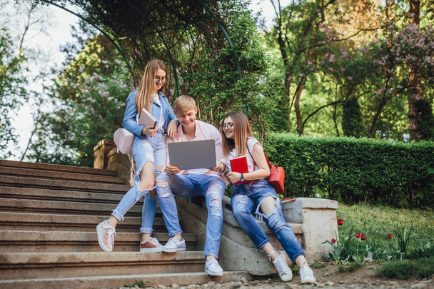 Group of young students sitting with laptop on stairs in campus - Fotoğraf, Görsel