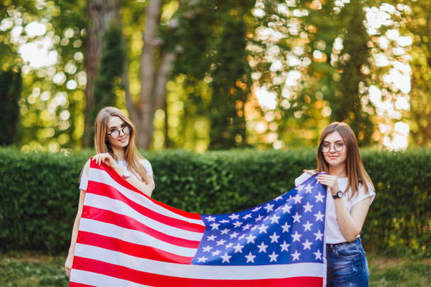 Two young women with american flag, selective focus - Foto, Imagen