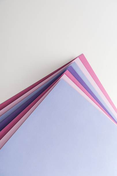 top view of blue, white, pink and purple sheets of paper on white background  - Photo, image