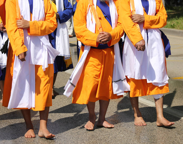tres sikh hombres con ropa naranja durante la ceremonia religiosa
 - Foto, imagen