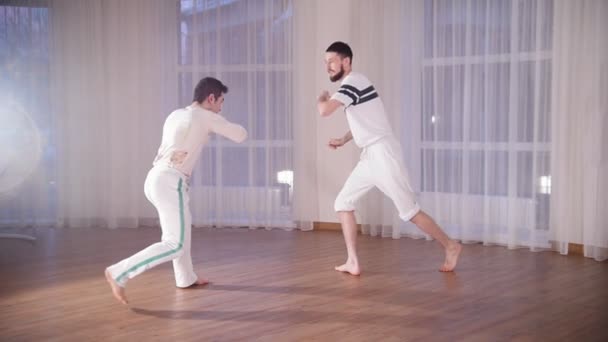 Capoeiraa. Kaksi miestä kouluttaa taitojaan. Potkiminen ja puolustaminen
 - Materiaali, video