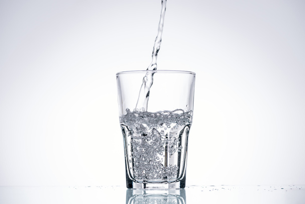 фон з водою, що ллється в склянці на білому з підсвічуванням
 - Фото, зображення