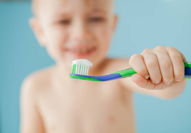 Portrait of little boy with toothbrush on blue background - Φωτογραφία, εικόνα