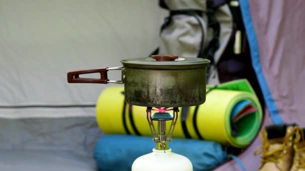 Het koken van voedsel in een tentenkamp. Video van een camping op het gazon van een bos. - Video