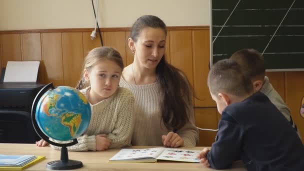učitel s dětmi zobrazí knihu - Záběry, video