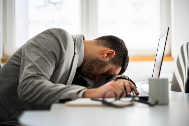 Young businessman is tired and overworked. - Photo, image
