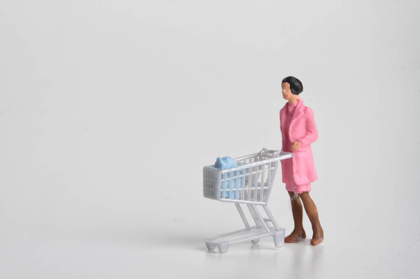 persone in miniatura con carrello per lo shopping e monete in denaro
 - Foto, immagini
