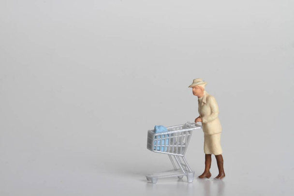 people miniature with cart for shopping and money coins - Fotoğraf, Görsel