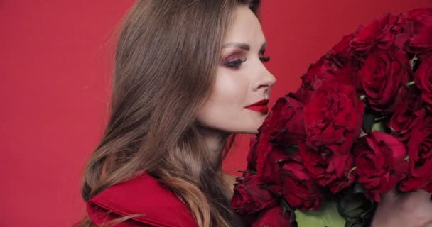 Gorgeous woman in red dress spinning with bouquet of roses - Video, Çekim