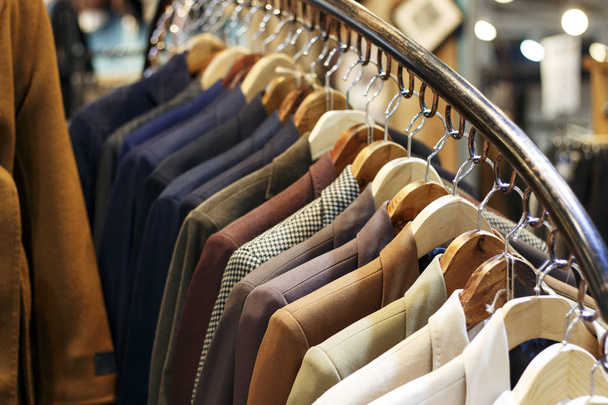 Stijlvolle mannen jassen op hangers in de winkel, close-up - Foto, afbeelding