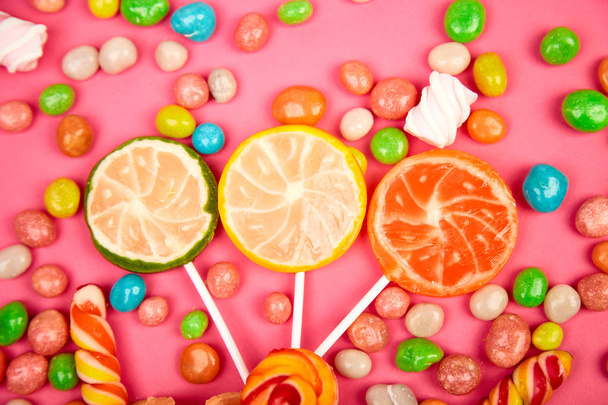 Colorful candy, jelly, lollipop on stick, scattering of multicolored sweets - Photo, Image