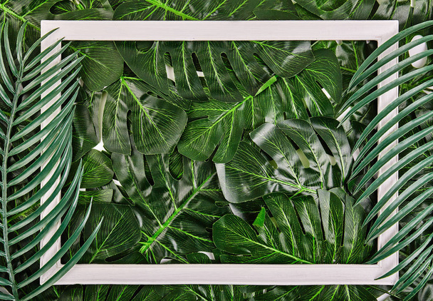 Creative layout made of tropical leaves with vintage frame. - Photo, Image