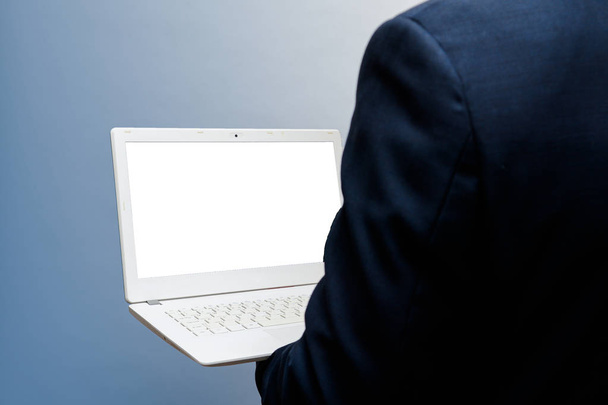 Ο άνθρωπος που χρησιμοποιούν φορητό υπολογιστή με κενή, λευκή οθόνη, πυροβόλησε πάνω από shoulde - Φωτογραφία, εικόνα
