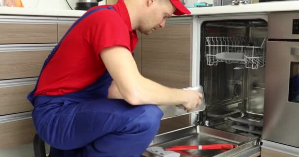 otthoni készülék karbantartó szolgálat-szerelőt dolgozik mosogatógéppel a hazai konyhában - Felvétel, videó