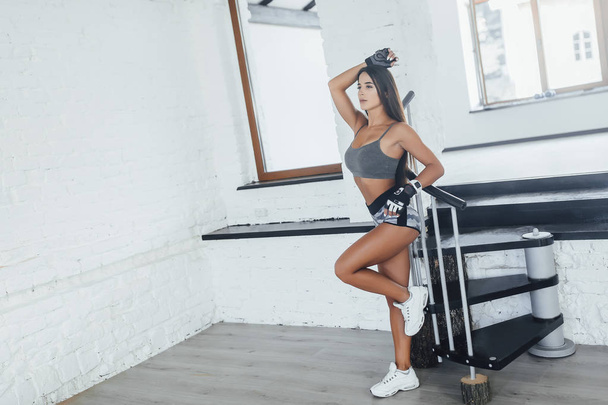 young beautiful woman in sportswear posing in modern gym - Fotografie, Obrázek