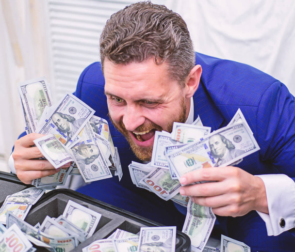 Handsome man happy and surprised with money hundreds dollars in case. Portrait of a happy young businessman throwing money banknotes. Money calculate. Profit, close up. - Fotoğraf, Görsel