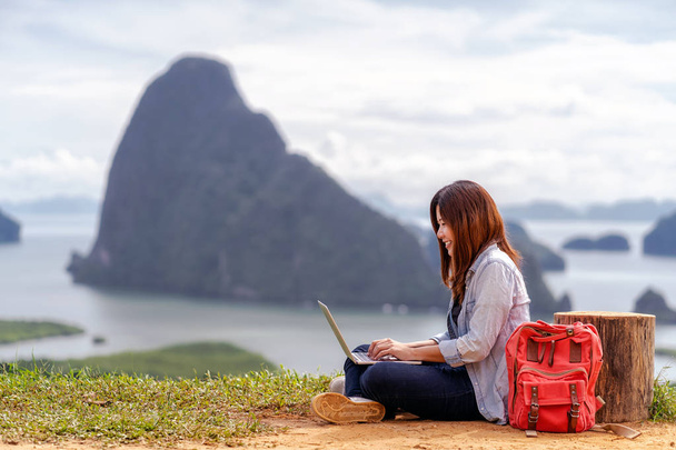 Aziatische vrouw freelancer werken met technologie laptop met geluk actie in een fantastisch landschap van Samed nang Chee View Point, freelance werken en reizen overal concept - Foto, afbeelding