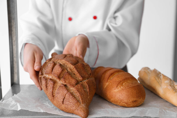 Naiskokki tuoreen leivän kanssa keittiössä
 - Valokuva, kuva