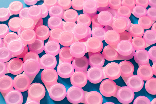 Pink contact lens cases on blue background - Fotografie, Obrázek