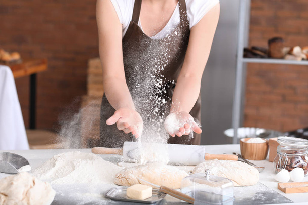Female baker making dough in kitchen - Foto, afbeelding