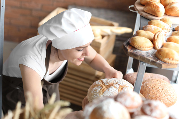 Žena kuchař s čerstvě upečeným chlebem v kuchyni - Fotografie, Obrázek