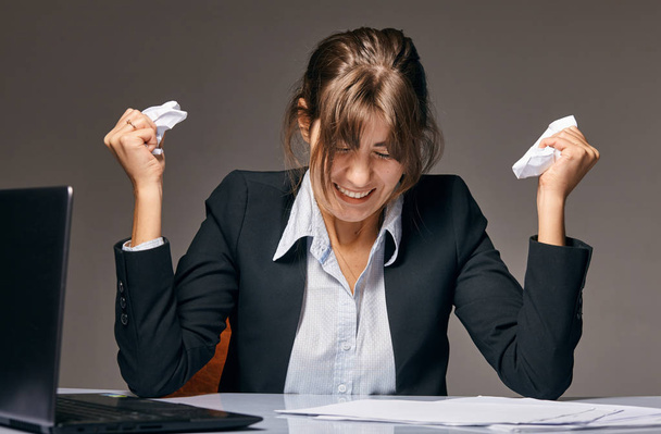 Businesswoman sitting at desk covered crumpled papers. Office worker tired of too much difficult unproductive work. Stressed female entrepreneur has no idea what to do with problem - Valokuva, kuva