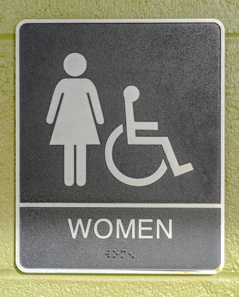 Panneau de toilettes pour femmes affiché sur un mur vert
 - Photo, image