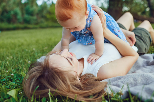 Woman with child lying on green meadow - Foto, Imagen