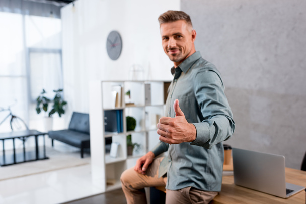 happy businessman showing thumb up in modern office - Foto, afbeelding