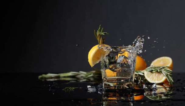 Gin-tonic con rodajas de limón y ramitas de romero
. - Foto, Imagen