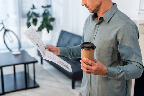 cropped view of businessman reading newspaper and holding paper cup  - Photo, Image
