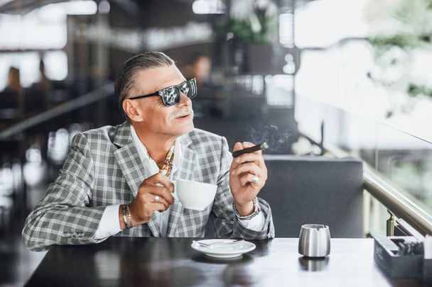 Stylish senior man in summer terrace chilling with cup of latte  - Foto, afbeelding